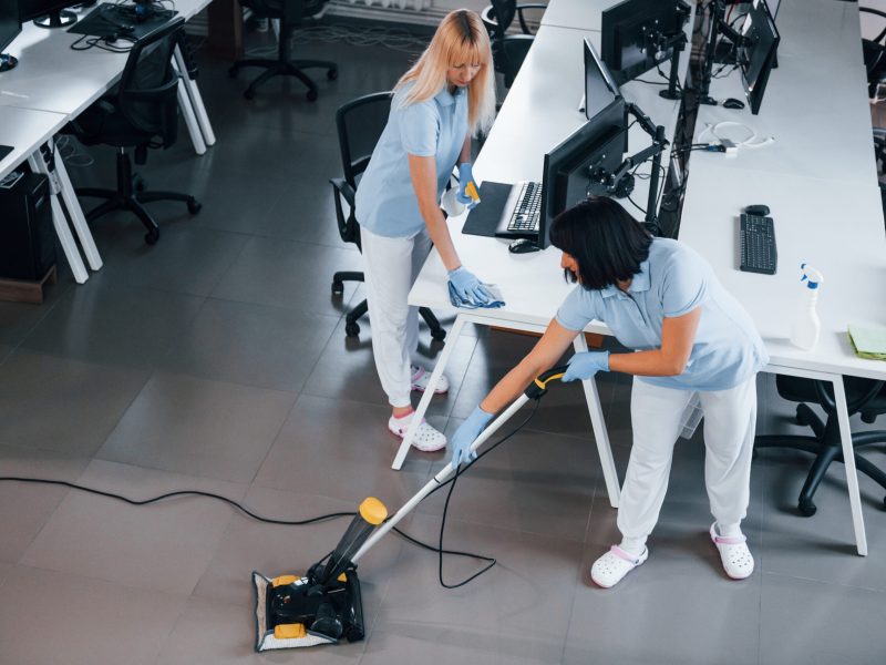 Concentrated at job. Group of workers clean modern office together at daytime.