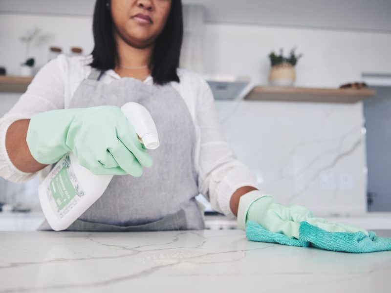 Woman, hands and cleaning kitchen table with spray bottle, detergent or bacteria or germ removal at.